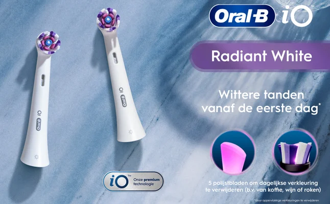 Image of two Oral-B iO toothbrush heads positioned on a blue marble background, with text that reads Oral-B iO, Radiant White, Wittere tanden vanaf de eerste dag*, and 5 polijstbladen om dagelijkse verkleuring te verwijderen (b.v. van koffie, wijn of roken).